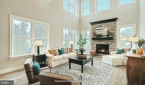 a living room with furniture a rug a fireplace and a large window