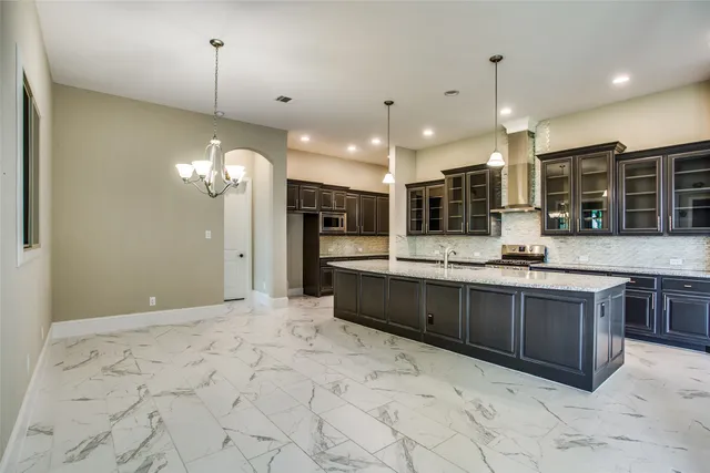 a large kitchen with kitchen island a sink stainless steel appliances and cabinets