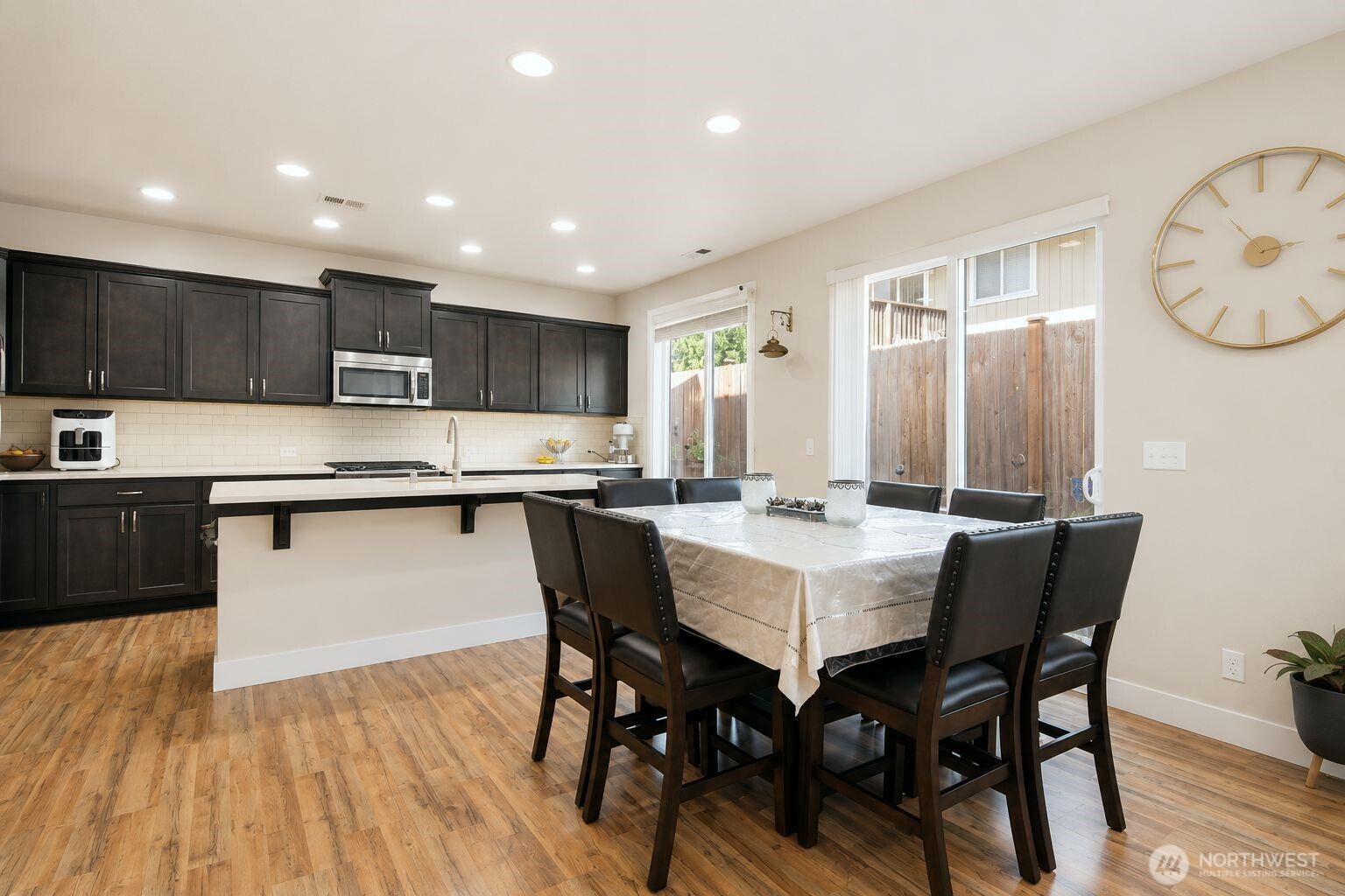 19607 25th Drive Southeast Bothell, WA 98012 - Photo 6 of 30 a kitchen with stainless steel appliances granite countertop a stove a refrigerator a sink dishwasher a dining table and chairs with wooden floor