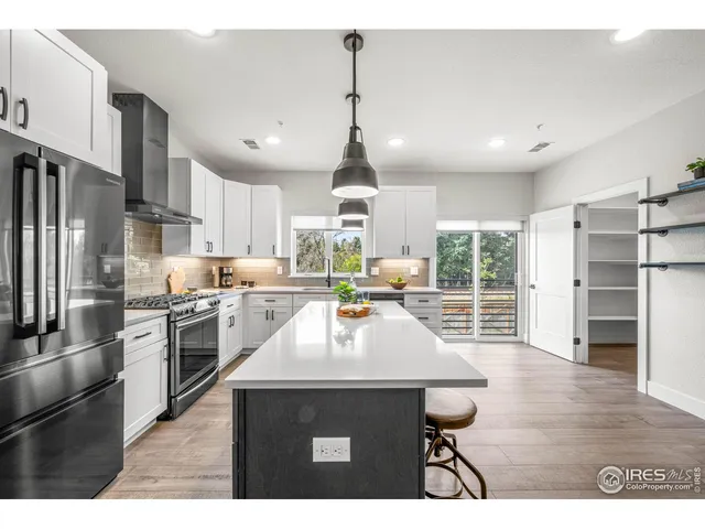 a kitchen with stainless steel appliances granite countertop a stove refrigerator and cabinets