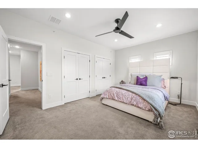 a bed room with a bed and a ceiling fan
