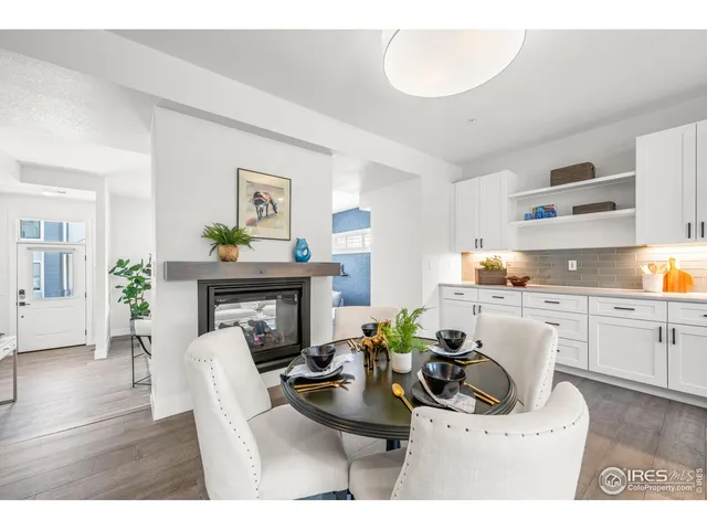 a living room with furniture a fireplace and kitchen view