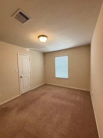 an empty room with a window and closet