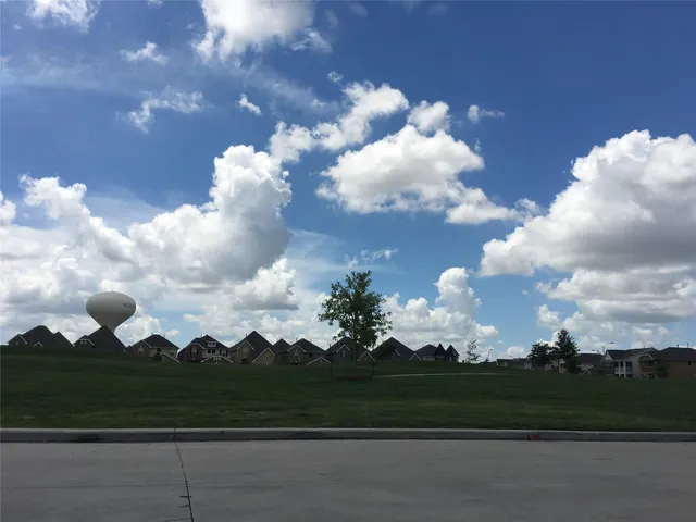 a view of a house with a yard and potted plants
