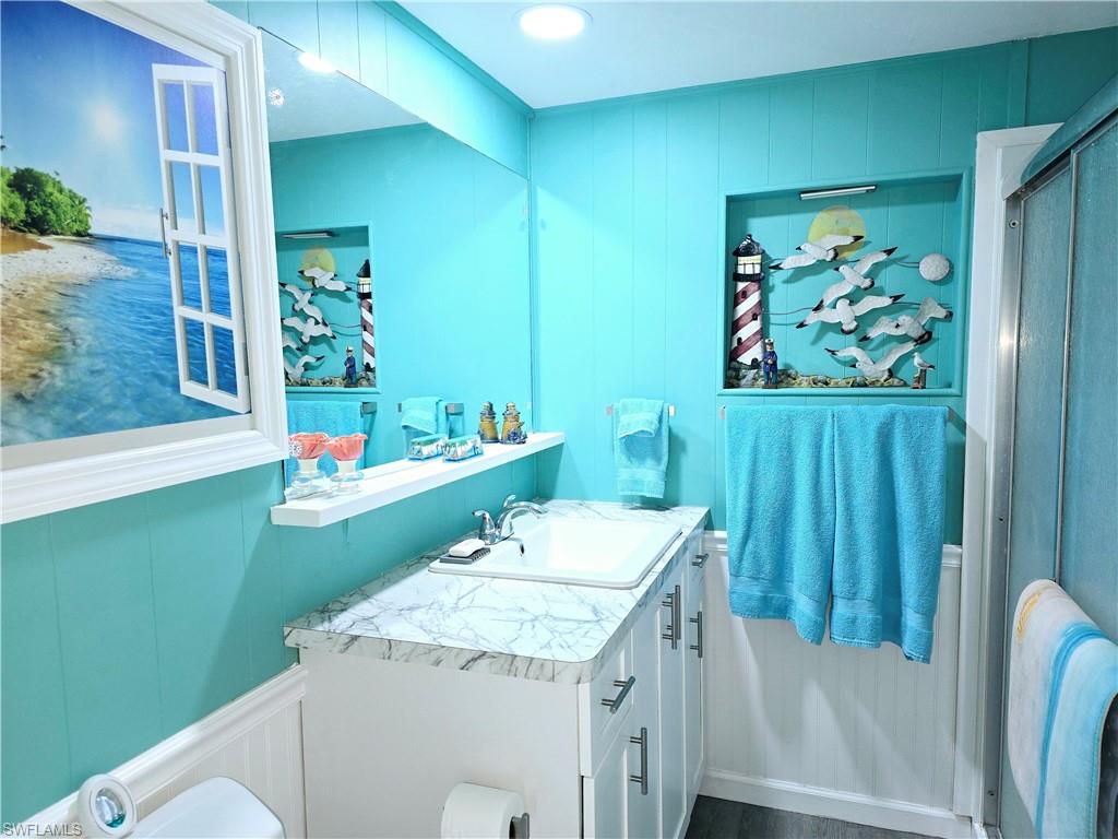 19 Moorhead Manor Naples, FL 34112 - Photo 15 of 33 a bathroom with a sink a mirror and a toilet