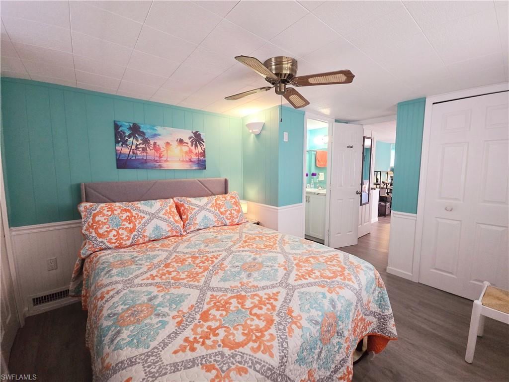 19 Moorhead Manor Naples, FL 34112 - Photo 22 of 33 a bedroom with a large bed and a chandelier