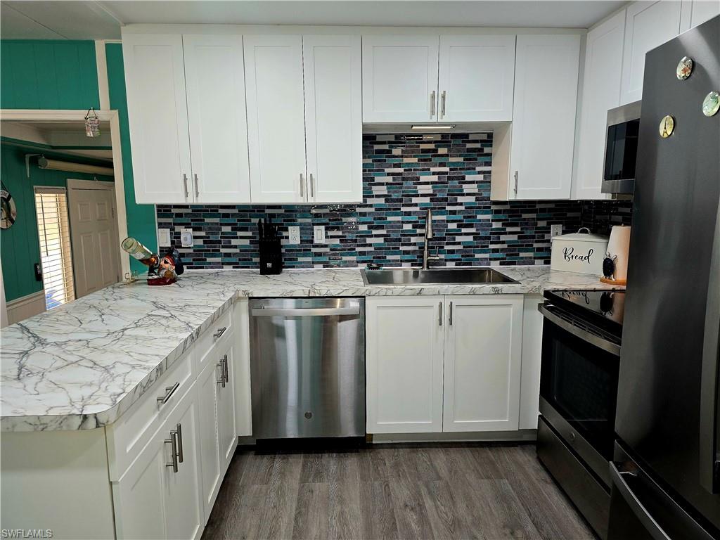 19 Moorhead Manor Naples, FL 34112 - Photo 7 of 33 a kitchen with granite countertop a sink a stove and cabinets