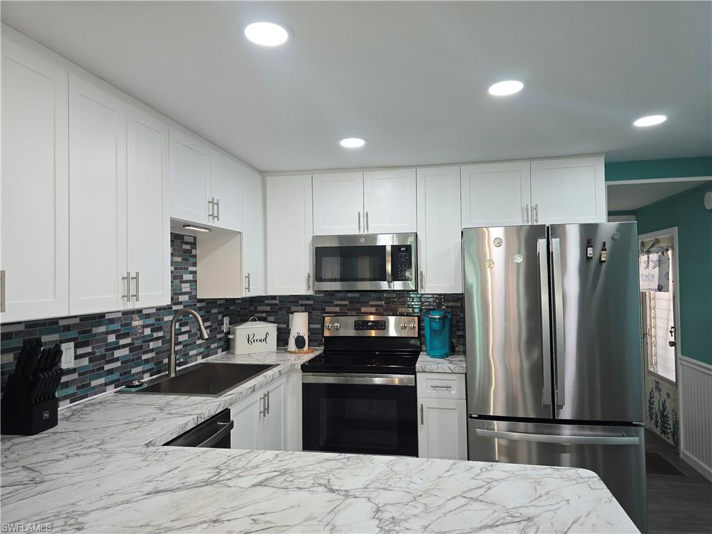 19 Moorhead Manor Naples, FL 34112 - Photo 9 of 33 a kitchen with granite countertop a refrigerator stove and sink