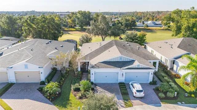 an aerial view of a house with a garden and lake view