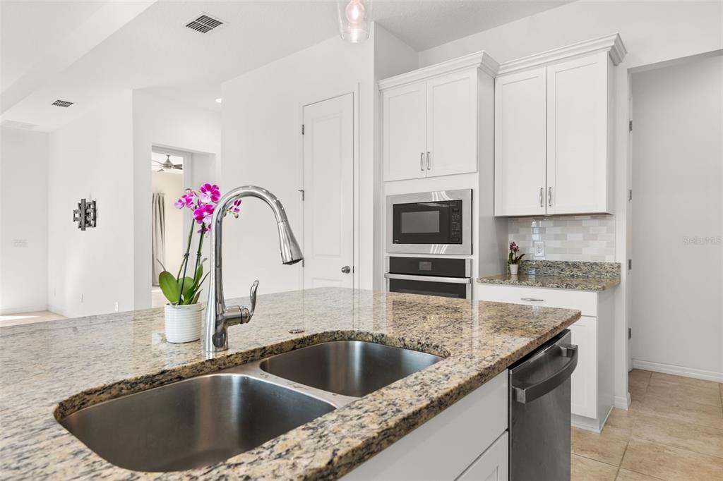 1855 Flora Pass Place Kissimmee, FL 34747 - Photo 18 of 41 a kitchen with a granite countertop sink a counter space and stainless steel appliances