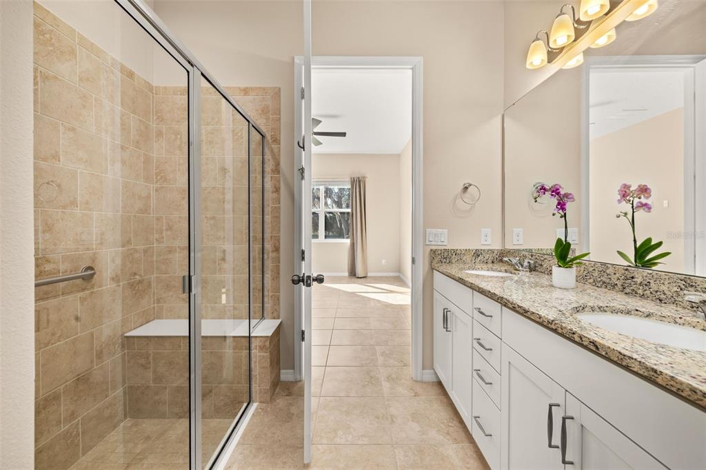 1855 Flora Pass Place Kissimmee, FL 34747 - Photo 20 of 41 a bathroom with a granite countertop sink a mirror and a shower