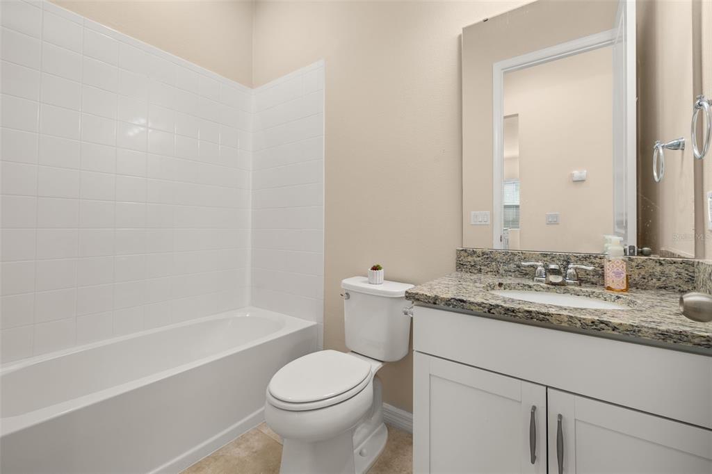 1855 Flora Pass Place Kissimmee, FL 34747 - Photo 27 of 41 a bathroom with a granite countertop sink toilet and shower