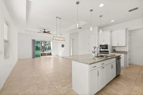 a kitchen with granite countertop stainless steel appliances a sink stove and cabinets