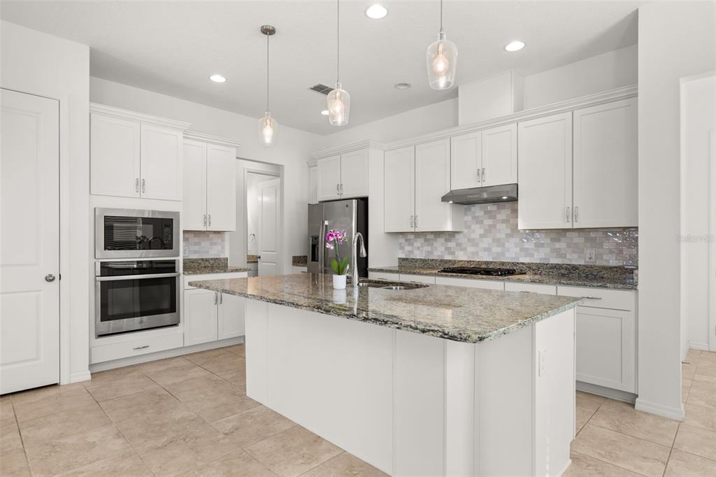 1855 Flora Pass Place Kissimmee, FL 34747 - Photo 7 of 41 a kitchen with stainless steel appliances granite countertop a sink stove and refrigerator