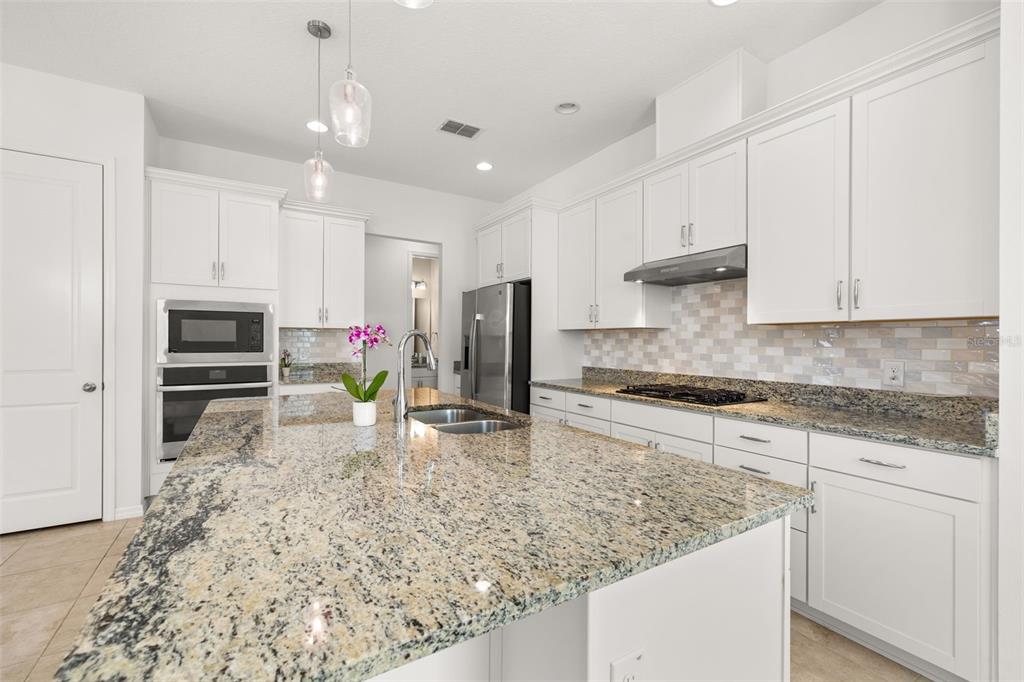 1855 Flora Pass Place Kissimmee, FL 34747 - Photo 9 of 41 a kitchen with stainless steel appliances granite countertop a sink stove and cabinets