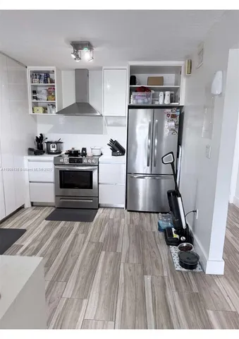 a kitchen with refrigerator and cabinets