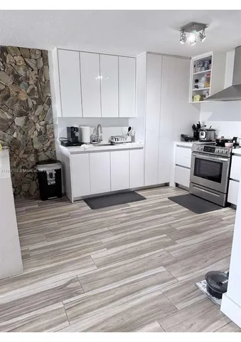 a kitchen with stainless steel appliances granite countertop a white cabinets and wooden floor