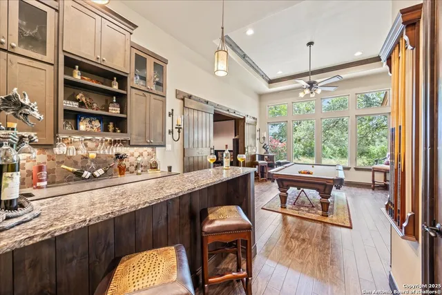 a kitchen with stainless steel appliances granite countertop sink stove and white cabinets with wooden floor