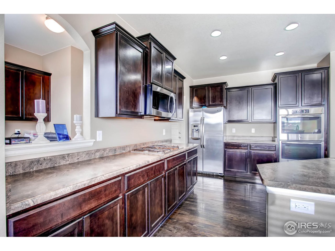 8615 Raspberry Drive Frederick, CO 80504 - Photo 14 of 28 a kitchen with stainless steel appliances granite countertop a stove a sink and a microwave