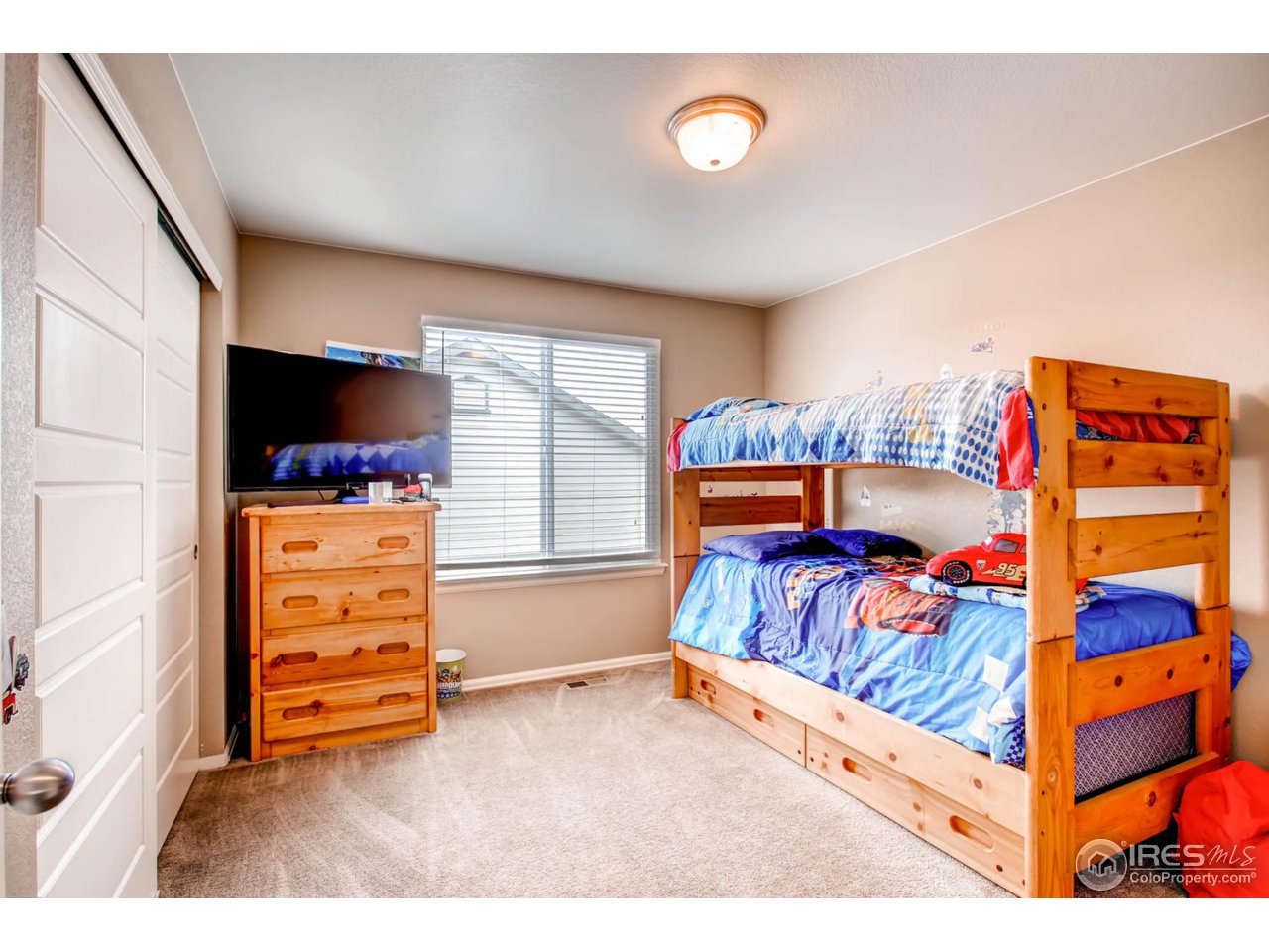 8615 Raspberry Drive Frederick, CO 80504 - Photo 22 of 28 a bedroom with a bed and a tv on the dresser