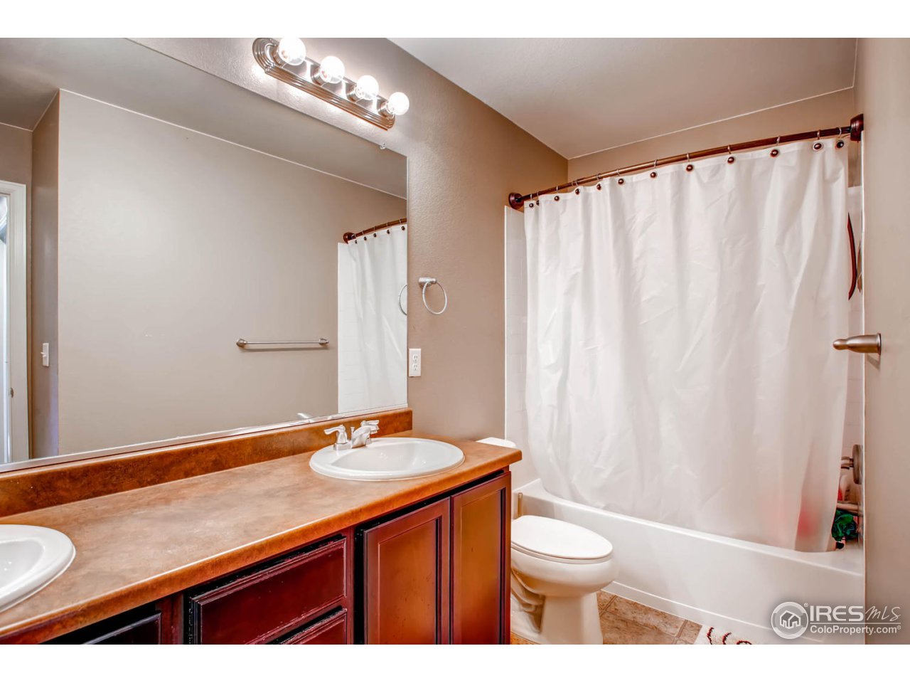 8615 Raspberry Drive Frederick, CO 80504 - Photo 24 of 28 a bathroom with a granite countertop sink and a mirror