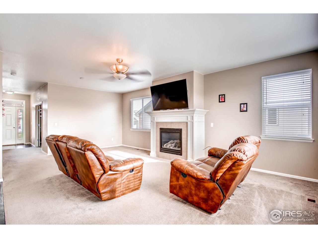 8615 Raspberry Drive Frederick, CO 80504 - Photo 6 of 28 a living room with furniture a fireplace and a flat screen tv