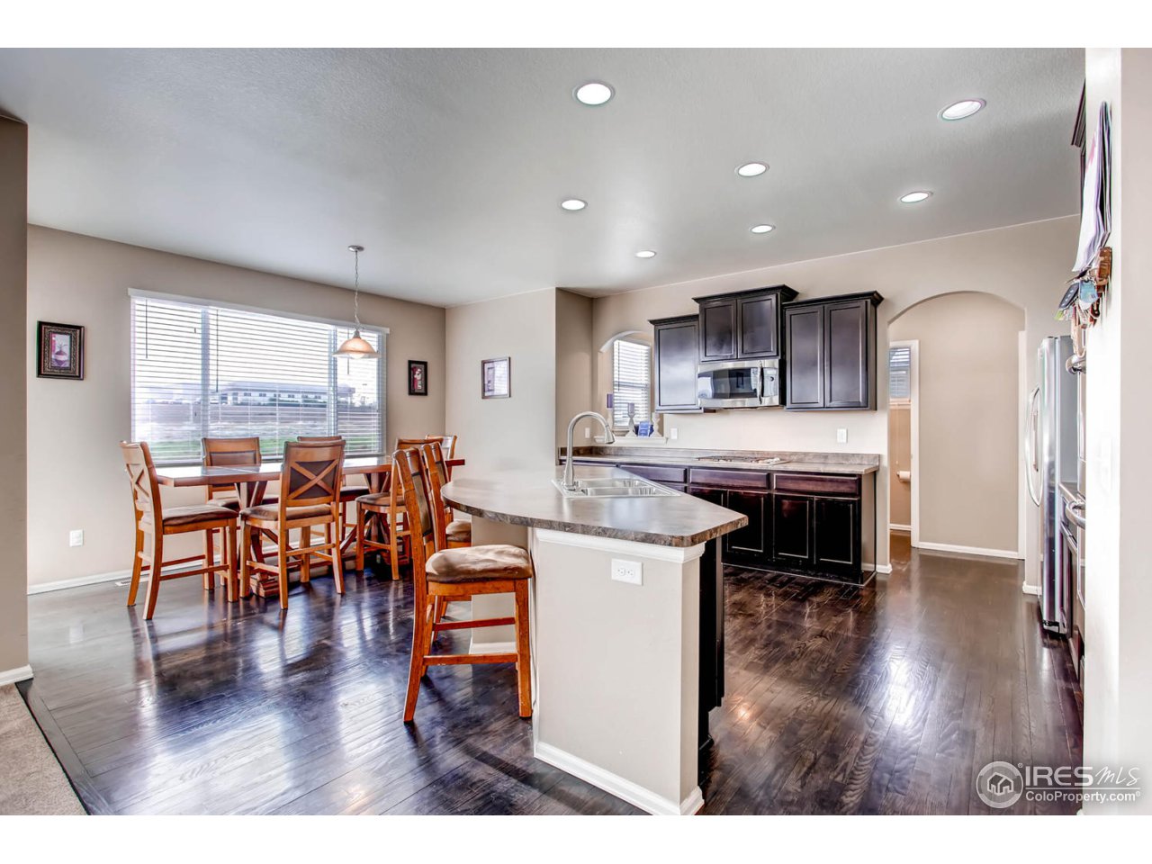 8615 Raspberry Drive Frederick, CO 80504 - Photo 7 of 28 a living room with stainless steel appliances kitchen island granite countertop furniture a dining table and chairs