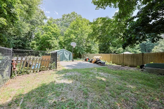 a view of a backyard with a bench and trees