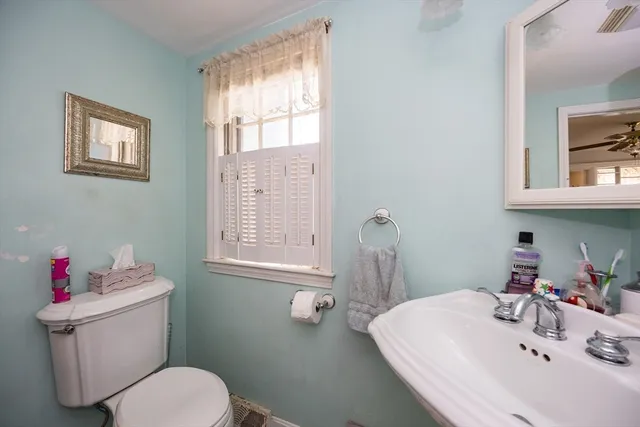 a bathroom with a sink toilet and a window