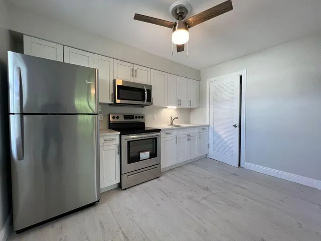 a kitchen with stainless steel appliances a refrigerator sink and microwave