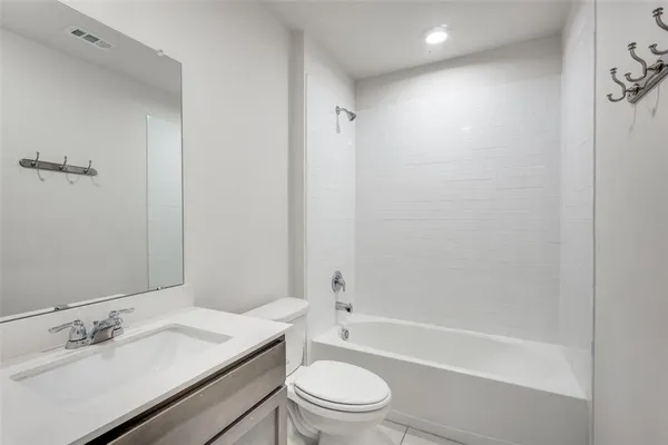 a bathroom with a bathtub shower sink vanity mirror and toilet