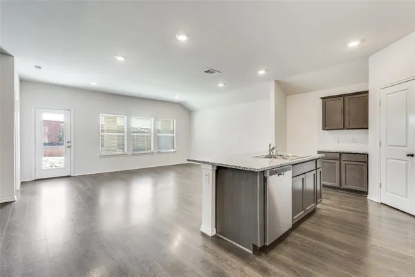 a kitchen with stainless steel appliances granite countertop a stove and a wooden floors