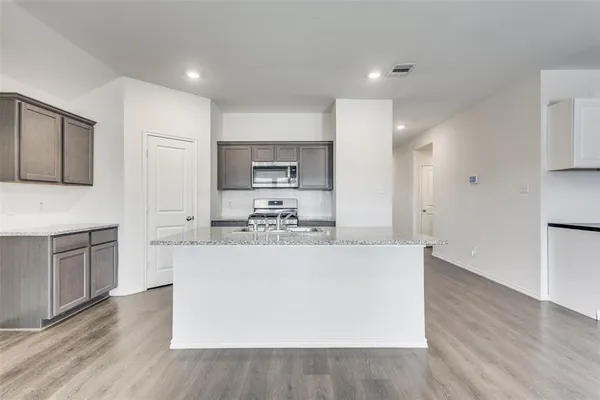 a large kitchen with a white stove top oven and white cabinets