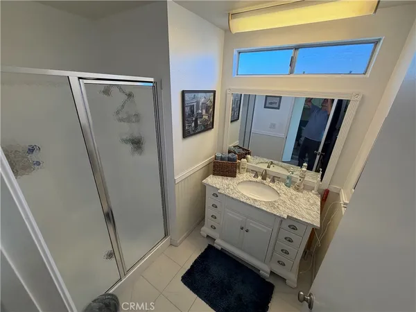 a bathroom with a granite countertop sink a mirror and a shower
