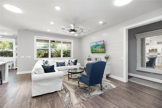 a kitchen with stainless steel appliances granite countertop a stove a sink dishwasher and a refrigerator with wooden floor