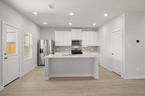 7906 Alset Magnolia, TX 77354 - Photo 4 of 11 a kitchen with stainless steel appliances granite countertop a refrigerator sink and white cabinets