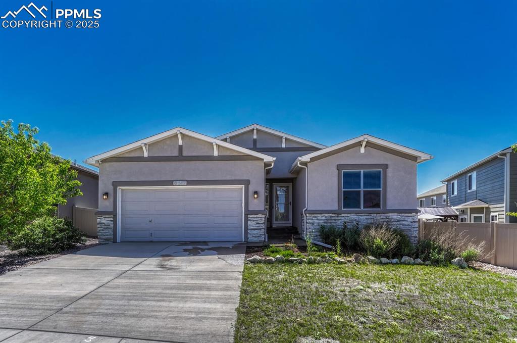 Experience the warm welcome of this property's frontage, where stone and stucco siding harmonize alongside a convenient driveway and attached garage.