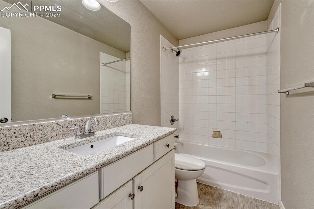 8437 Salt Brush Road Colorado Springs, CO 80908 - Photo 3 of 45 Bathroom featuring a vanity, shower/washtub combination, hardwood floors, and a textured wall finish.