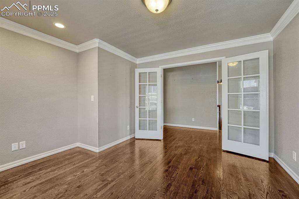 8437 Salt Brush Road Colorado Springs, CO 80908 - Photo 5 of 45 Step into a haven of refinement and efficiency, where french doors, intricate moulding, beautiful wood floors, and subtle recessed lighting create the perfect atmosphere.