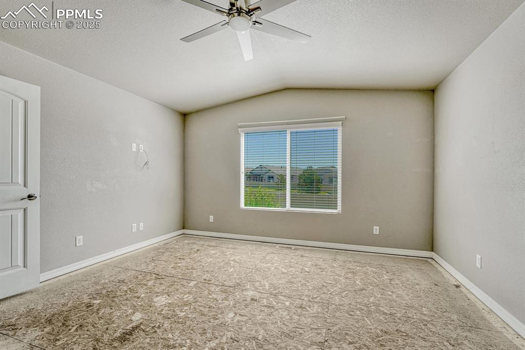 8437 Salt Brush Road Colorado Springs, CO 80908 - Photo 6 of 45 Envision your dream bedroom in this spacious primary suite, complete with a ceiling fan and vaulted ceiling, where you can add your personal style to the unfinished floors and make it truly yours.