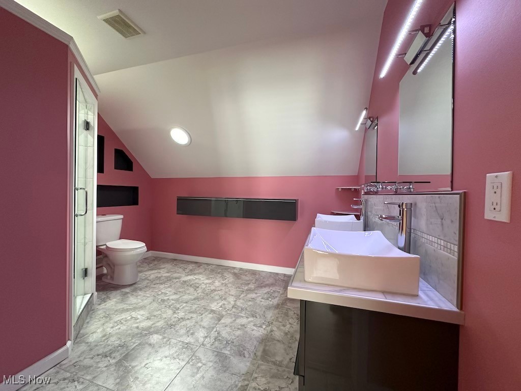 6846 Ottawa Road Cleveland, OH 44105 - Photo 35 of 50 Full bathroom with visible vents, toilet, a sink, baseboards, and vaulted ceiling