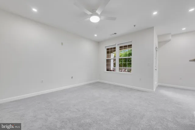 an empty room with a window and a kitchen
