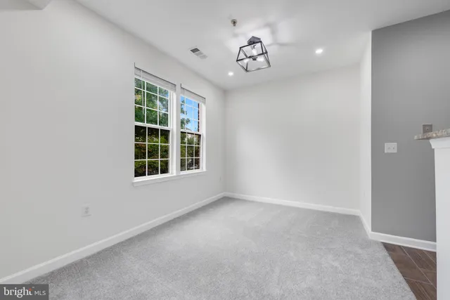 an empty room with kitchen and fireplace