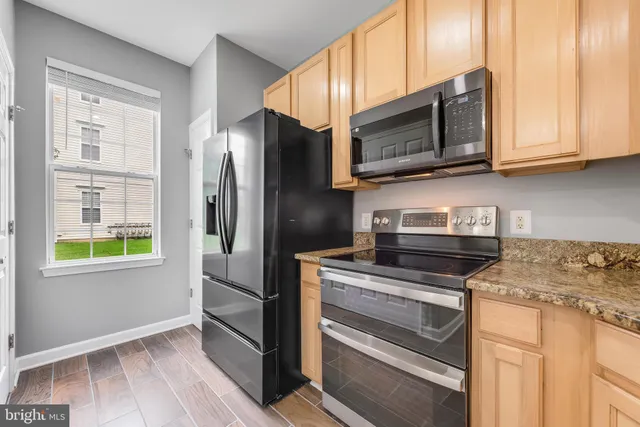 a kitchen with stainless steel appliances granite countertop a stove and a microwave