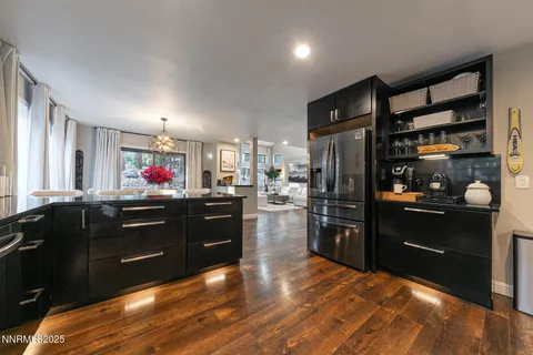 a kitchen with stainless steel appliances kitchen island granite countertop a refrigerator a stove top oven and a sink