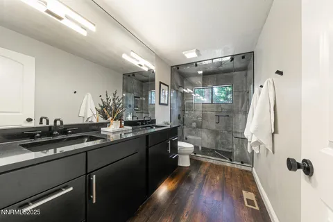 a bathroom with a double vanity sink toilet and shower
