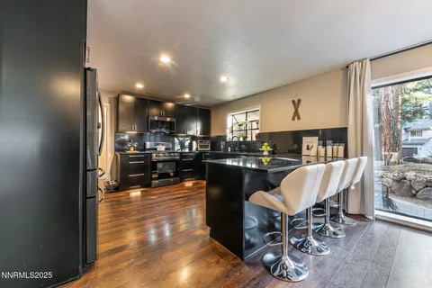 a living room with furniture a kitchen island dining table and a sink