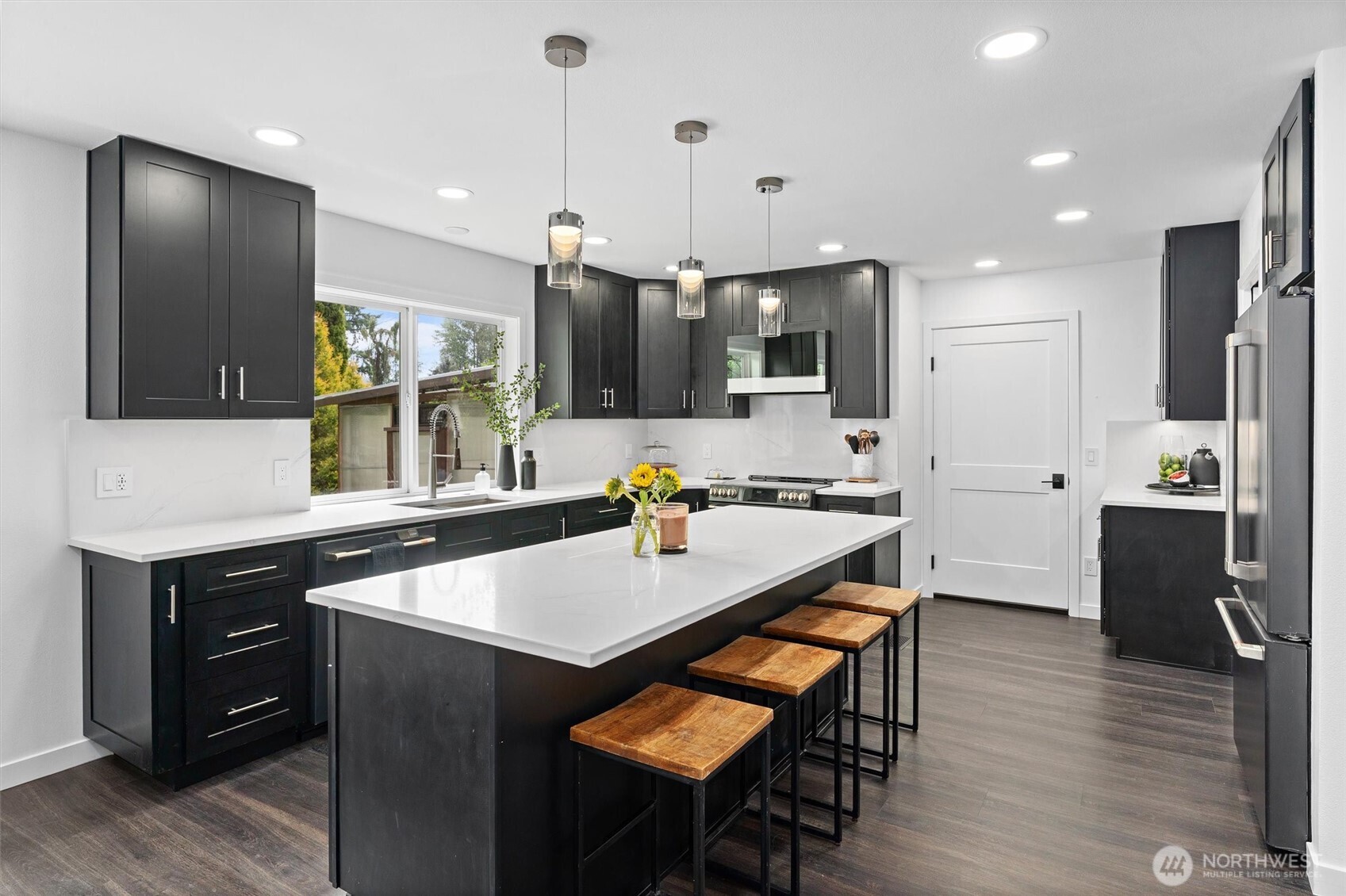 16100 Southeast 113th Place Renton, WA 98059 - Photo 11 of 40 a kitchen with stainless steel appliances a sink a stove a refrigerator a microwave a stove and white cabinets with wooden floor