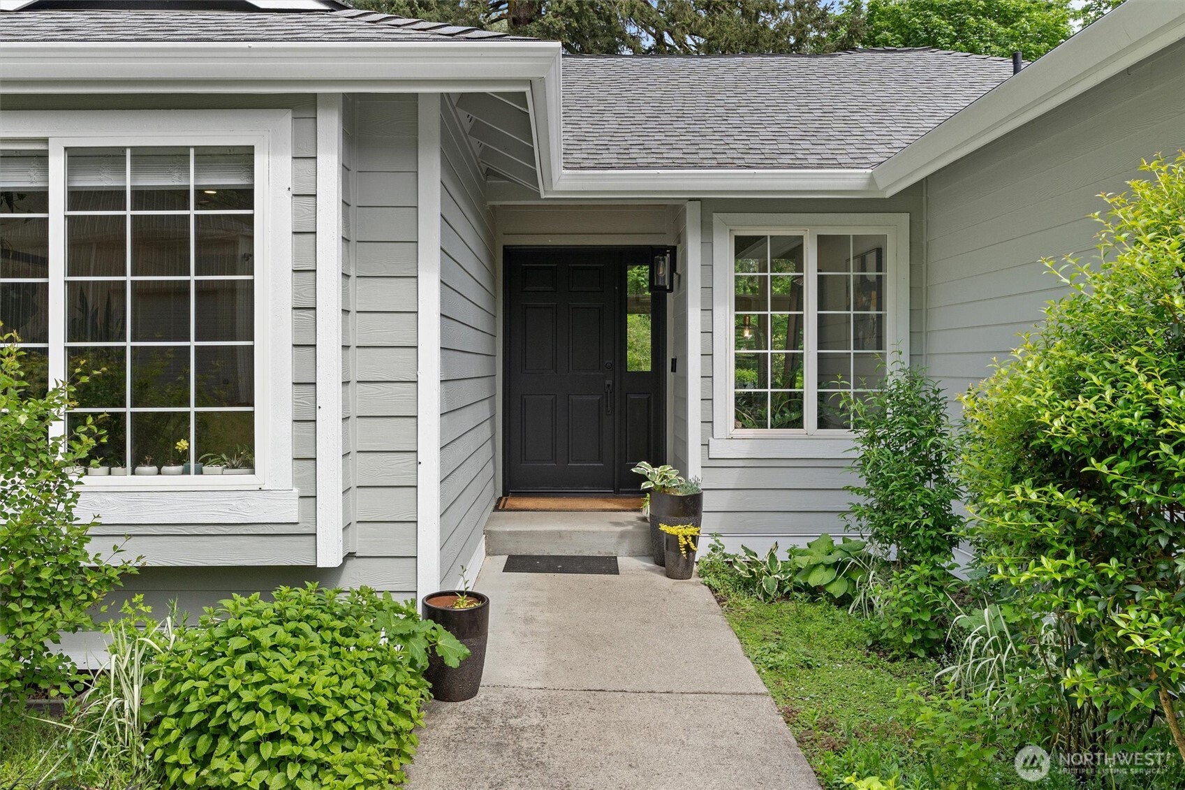 16100 Southeast 113th Place Renton, WA 98059 - Photo 4 of 40 a front view of a house with a yard and potted plants