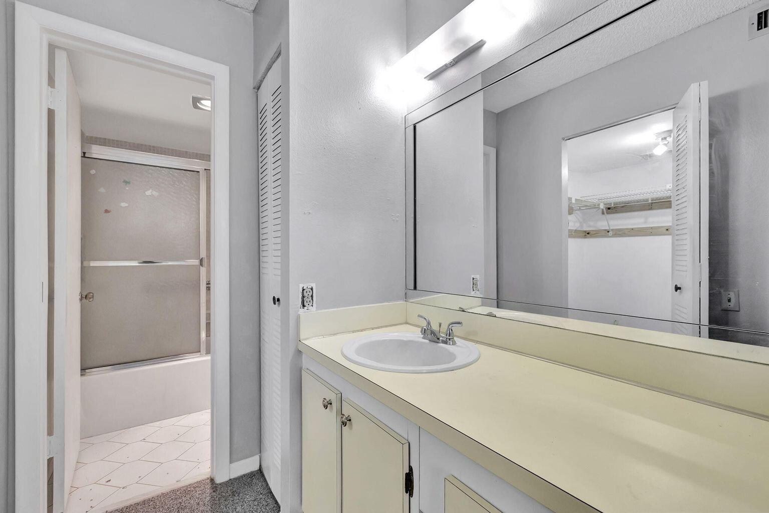 9300 Lime Bay Boulevard, Unit 302 Tamarac, FL 33321 - Photo 11 of 15 a bathroom with a sink and a mirror